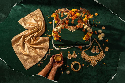 Indian wedding trends 2026 flat lay — champagne lehenga fabric, marigolds, henna hands and gold jewellery by ZIVAARA Studio
